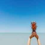Diät im Urlaub / Ananas am Meer – gesunde Ernährung und Leichtigkeit symbolisieren eine entspannte Diät im Urlaub