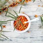 Foto: <a href="https://stock.adobe.com/de/images/natural-organic-sea-buckthorn-berry-in-bowl-and-a-on-white-wooden-background-branch-of-sea-buckthorn-top-view/289053179" target="_blank" rel="noopener">bondarillia / stock.adobe.com</a> Sanddorn