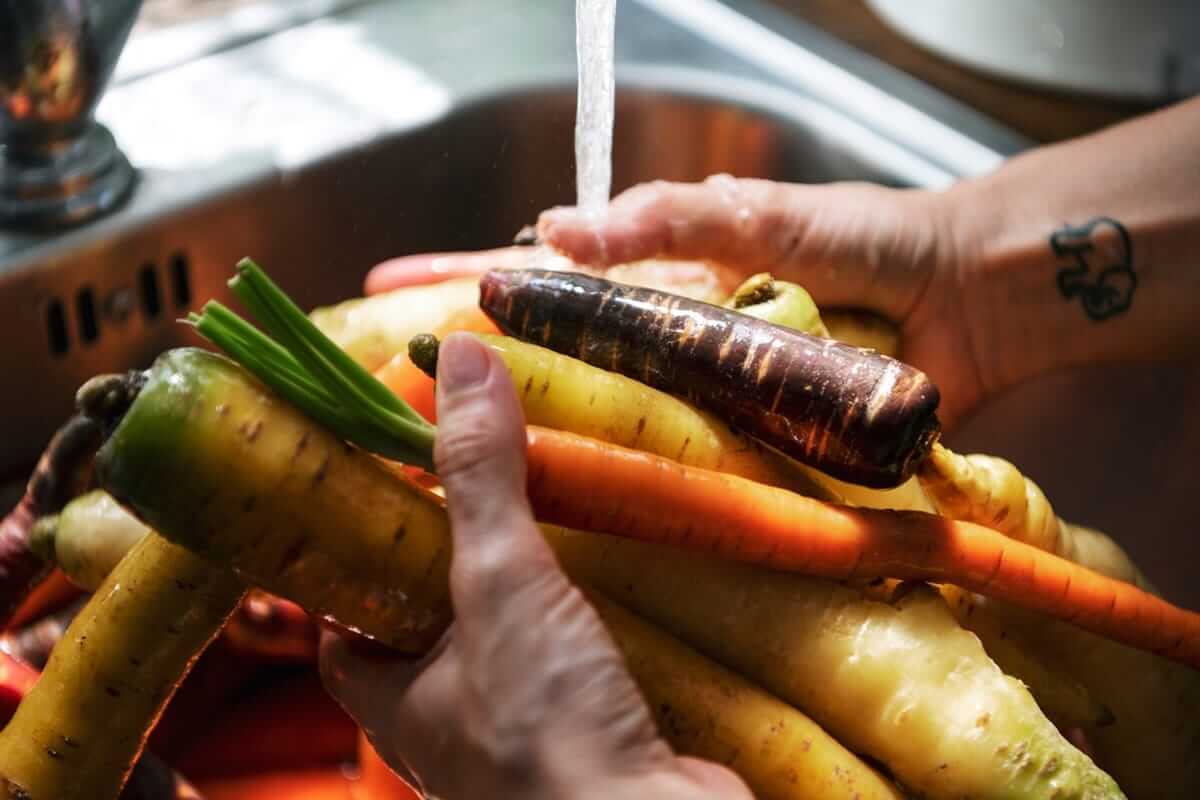 Clean-Eating-Rezepte (Chef cleaning carrots and turnips in the sink)