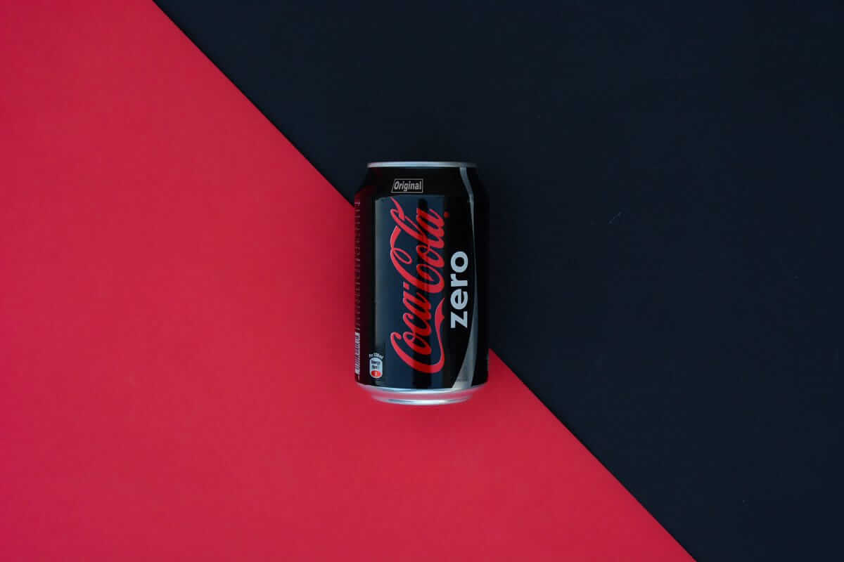 Kalorienfreie Lebensmittel / Coca-Cola Zero Dose auf rote-schwarzem Hintergrund