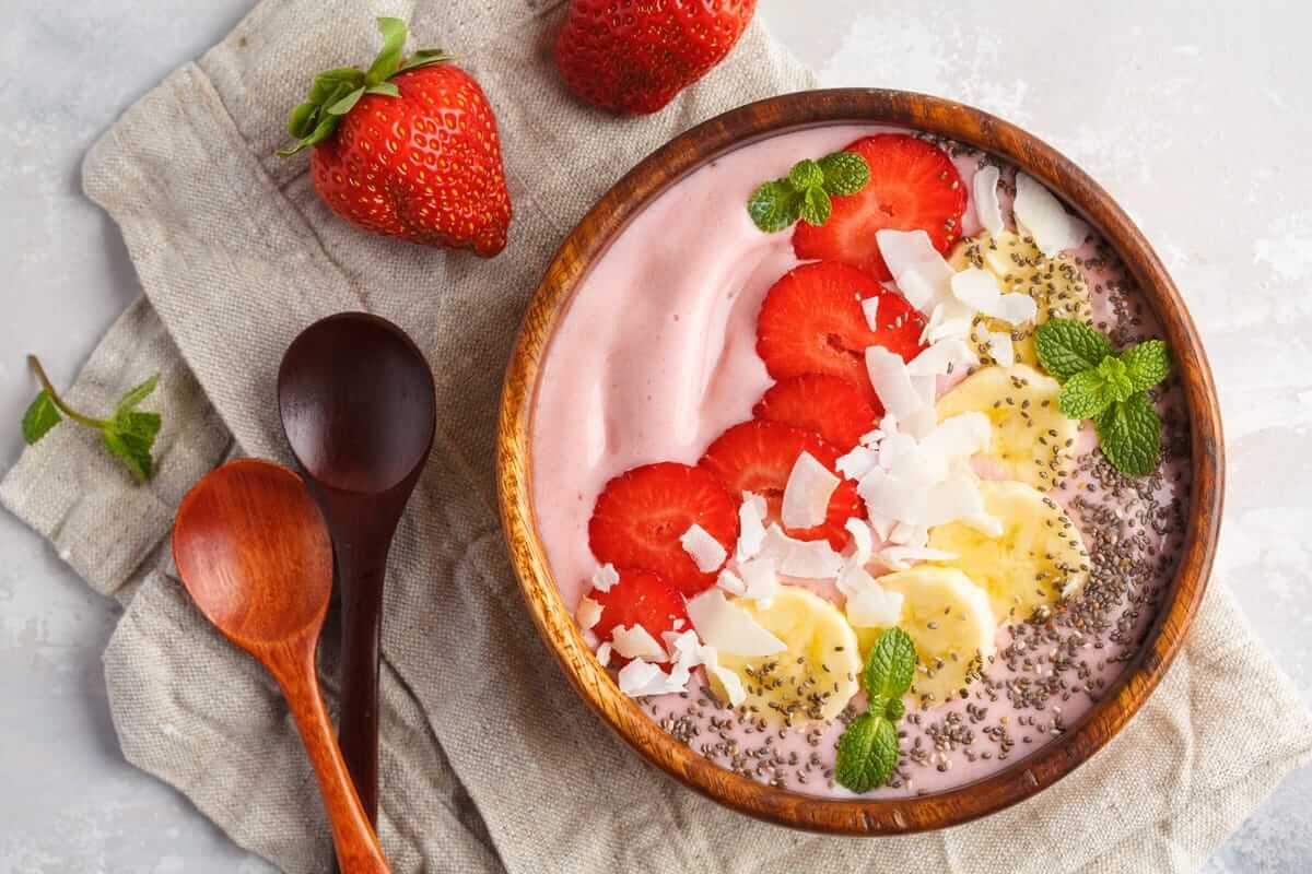 Joghurt-Beeren-Chia-Bowl, Strawberry pink smoothie bowl with banana, coconut and chia seeds