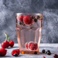 Glas mit Kirschen und Beeren – Kirschen können den Harnsäurespiegel bei Gicht senken