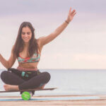 Gleichgewicht / a woman sitting on a skateboard with her hand up