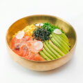 flexitarisch genießen / Bunte Bowl mit Avocado, Lachs, Mais, Algen und Radieschen in goldener Schale – Symbol für flexitarische Ernährung mit bewusster Auswahl.