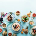 Cheat Day, Genussmomente (Bunter Frühstückstisch mit frischem Obst, Joghurt, Nüssen, Croissant und Muffin – Balance zwischen gesundem Genuss und kleinen Sünden.)