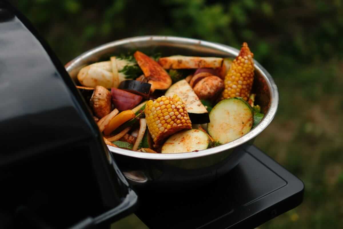 Herbstliche Resteverwertung – Nachhaltig genießen statt wegwerfen Herbstliche Resteverwertung / Schüssel mit buntem Grillgemüse aus Zucchini, Mais, Aubergine und Zwiebeln – herbstliche Resteverwertung auf dem Grill