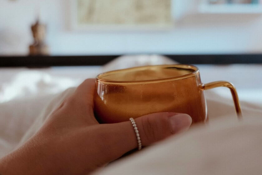 Warme Tasse Tee in der Hand als Symbol für bewussten Genuss und einen entspannten Moment im Alltag