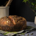 Brot / Textur und Konsistenz (Dunkles Körnerbrot mit kräftiger Kruste und sichtbaren Saaten auf einem Tuch)