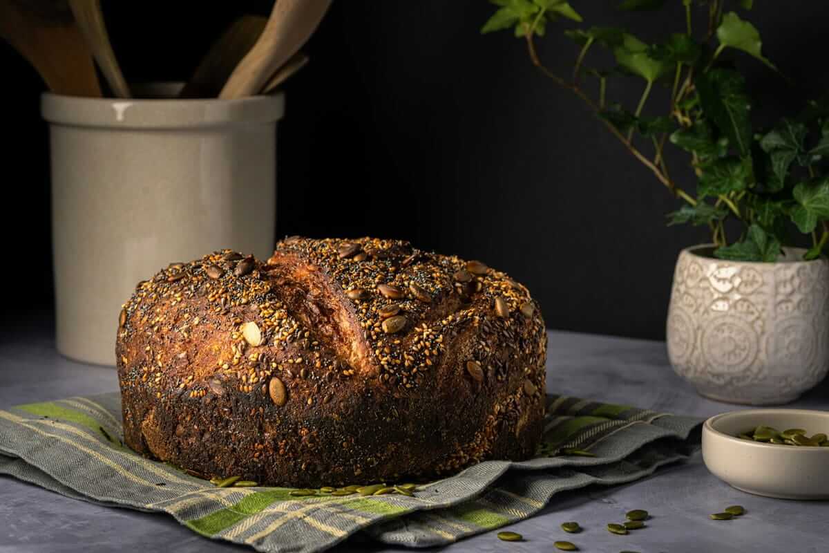 Textur statt Superfood: Warum Konsistenz beim Essen wichtiger wird Brot / Textur und Konsistenz (Dunkles Körnerbrot mit kräftiger Kruste und sichtbaren Saaten auf einem Tuch)