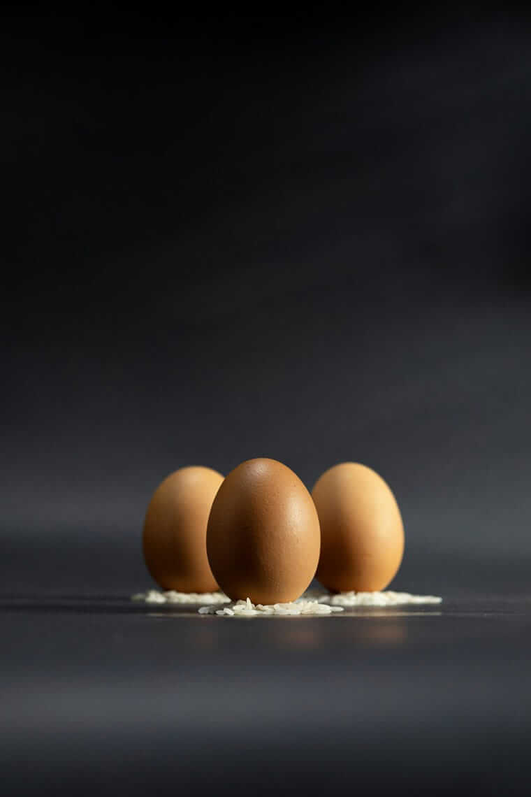 Reduktion / Drei braune Eier auf dunklem Hintergrund