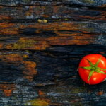Reduktion / rote Tomate auf braunem Stamm