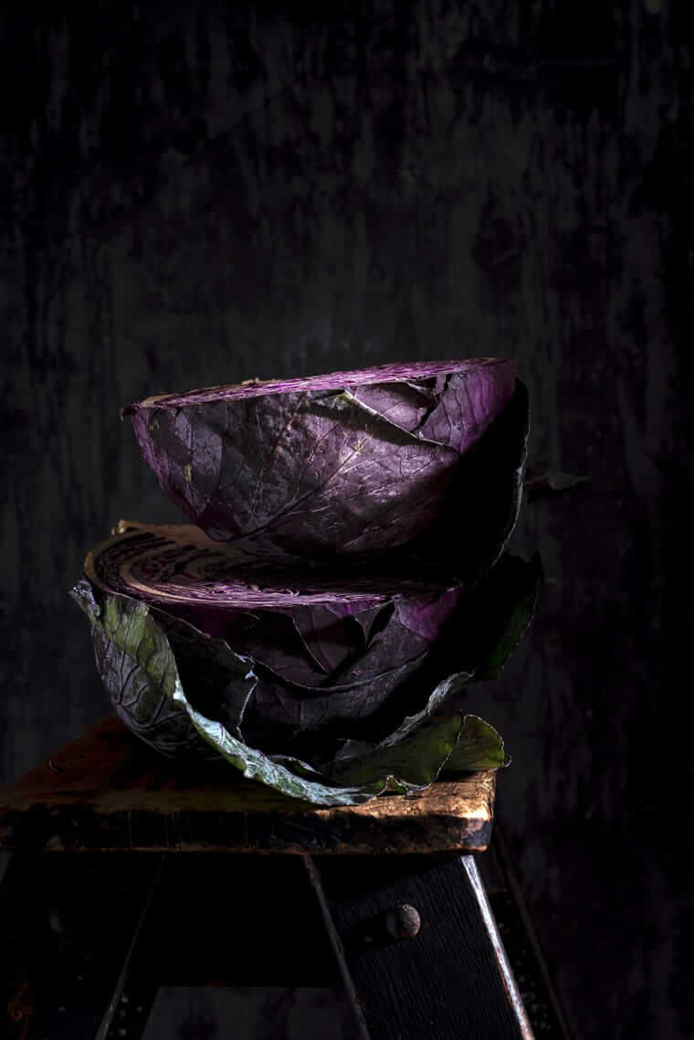 einfache Gemüsesorten / Aufgeschnittener Rotkohl gestapelt auf rustikalem Holz – intensive Purpurfarbe und Struktur