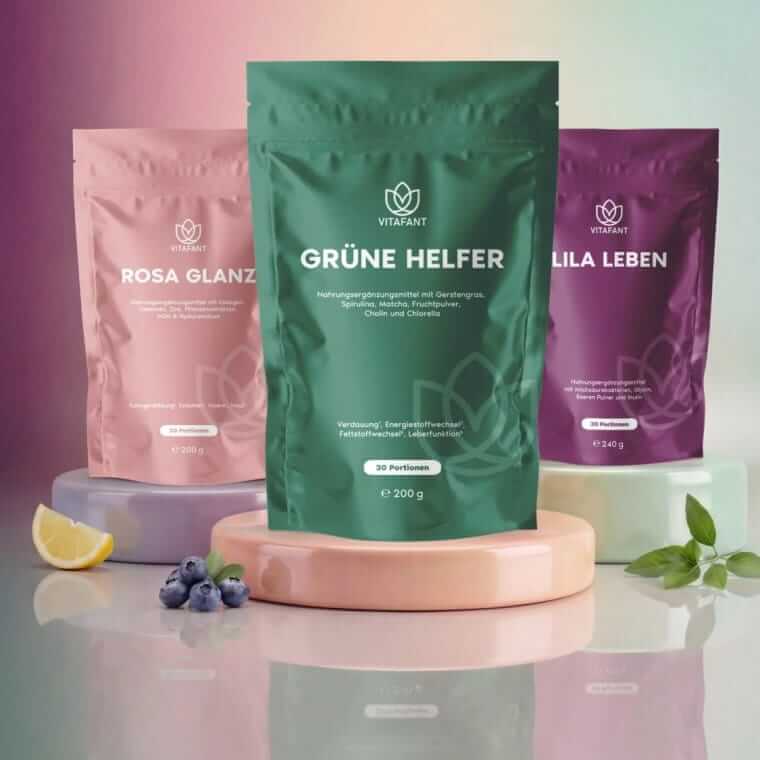 Drei Vitafant-Produkte in Pulverform: Grüne Helfer, Lila Leben und Rosa Glanz in farbigen Standbeuteln auf Produktpodesten.