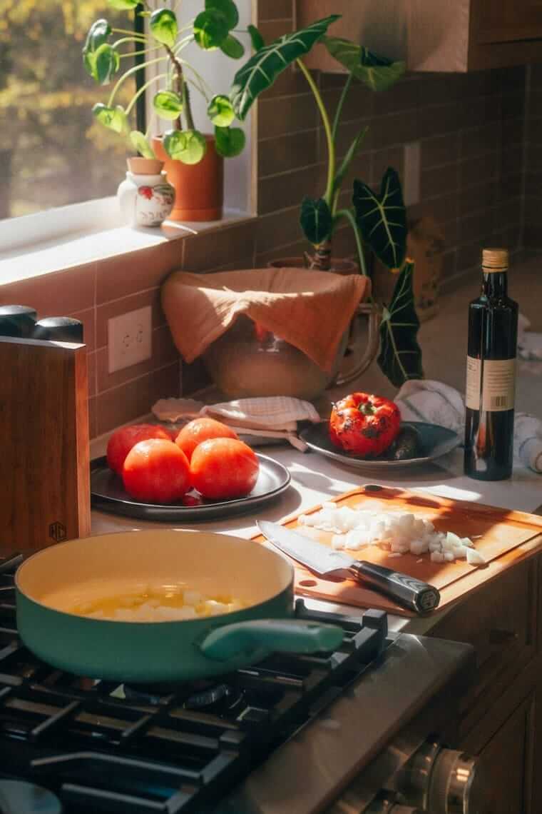 Einfaches Meal-Prep: Drei Techniken statt Großvorbereitung Küchenzeile mit Topf, Pfanne, Schneidebrett und frischen Tomaten – einfache Ausstattung für die Essensvorbereitung