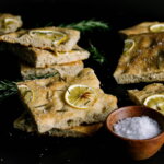Geschmacksschichten / Focaccia mit Zitrone, Rosmarin, Salz auf dunklem Untergrund