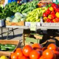Saisonales Gemüse im Sommer / Wochenmarktstand mit Tomaten, Paprika und Zucchini – typisches Sommerangebot aus regionalem Anbau.