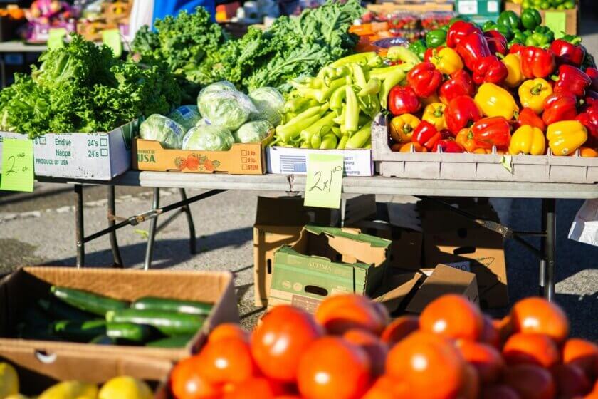 Saisonales Gemüse im Sommer / Wochenmarktstand mit Tomaten, Paprika und Zucchini – typisches Sommerangebot aus regionalem Anbau.
