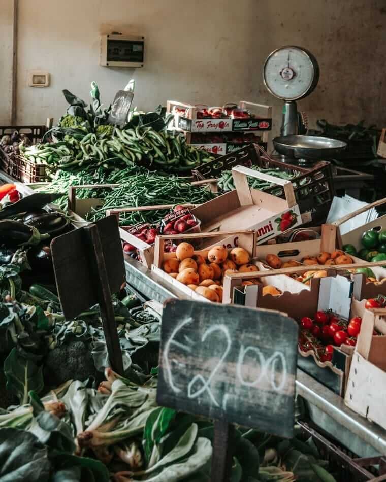 Handgeschriebenes Preisschild auf Marktstand mit frischem Gemüse – Preis als Hinweis auf Saisonware
